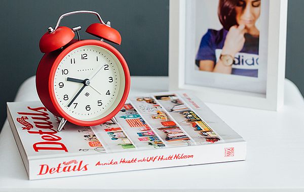 Roter Retro-Wecker auf Buch