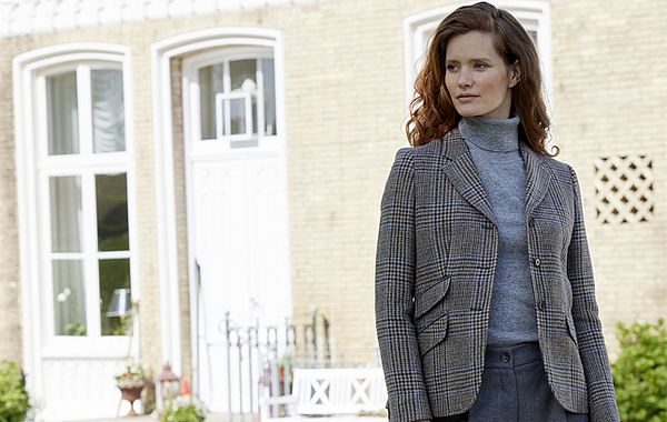 Frau trägt Blazer, Rollkragenpullover und Wollhose im monochromen Look