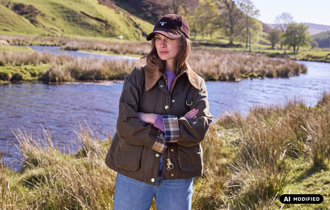 Frau in Barbour-Jacke vor Flüsschen