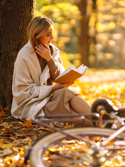 Frau lesend im Herbst