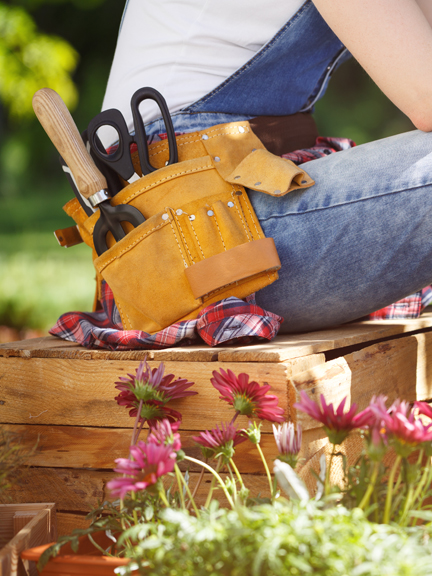 Frau mit Hüftgürtel mit Garten-Tools