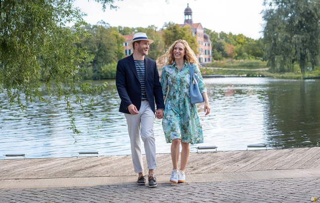 Paar in legerer Kleidung vor einem Gewässer