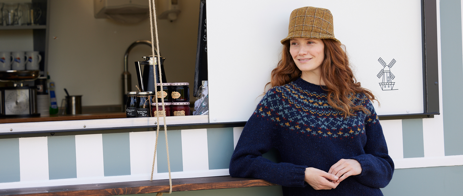 Frau im Fair-Isle-Pulli mit Tweed-Hut