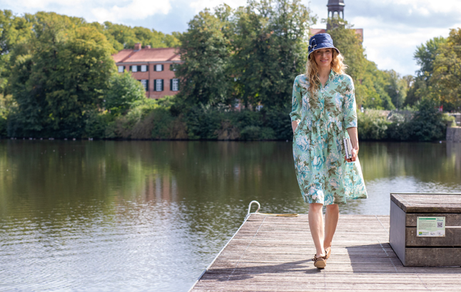 Frau auf Steg in geblümten Sommerkleid