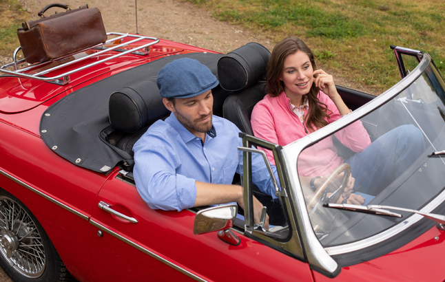 Paar fährt im roten Cabriolet